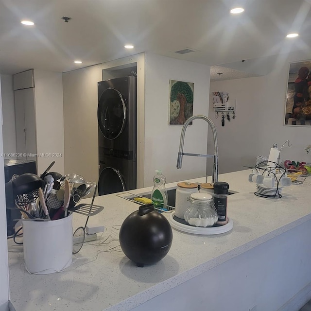 interior space featuring light stone countertops and stacked washer and clothes dryer