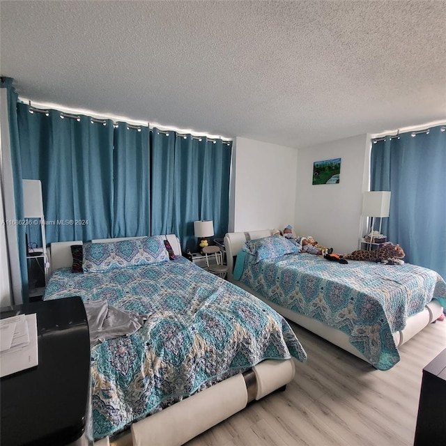 bedroom featuring a textured ceiling and wood-type flooring