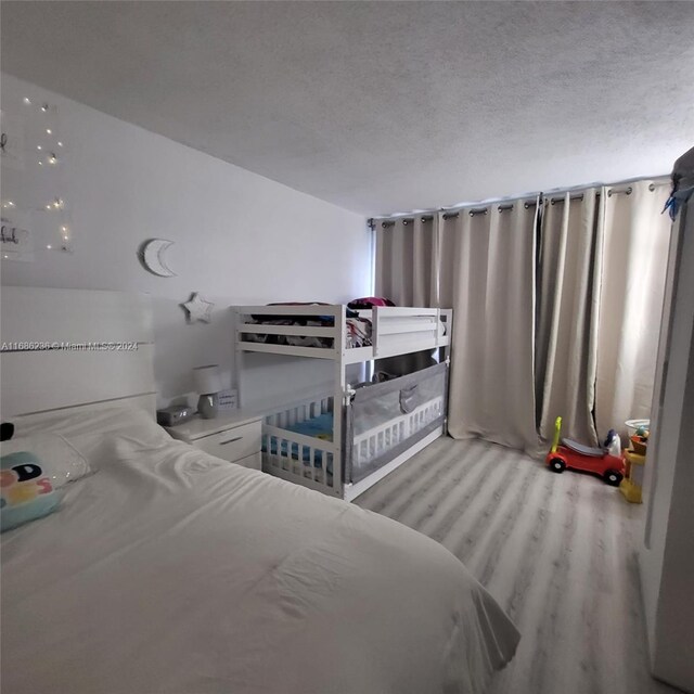 bedroom with a textured ceiling and light wood-type flooring