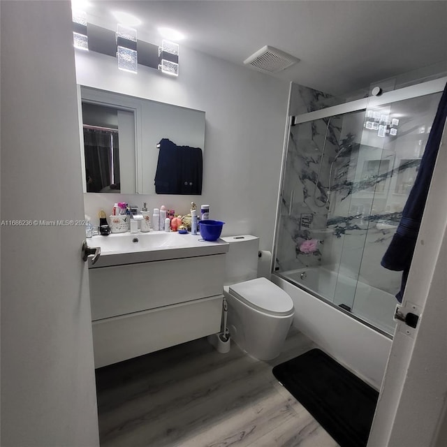 full bathroom featuring vanity, toilet, enclosed tub / shower combo, and hardwood / wood-style floors