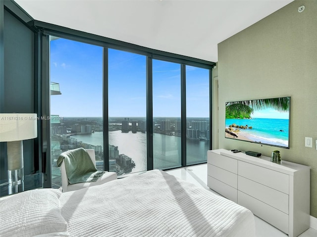 bedroom featuring a wall of windows, multiple windows, and a water view