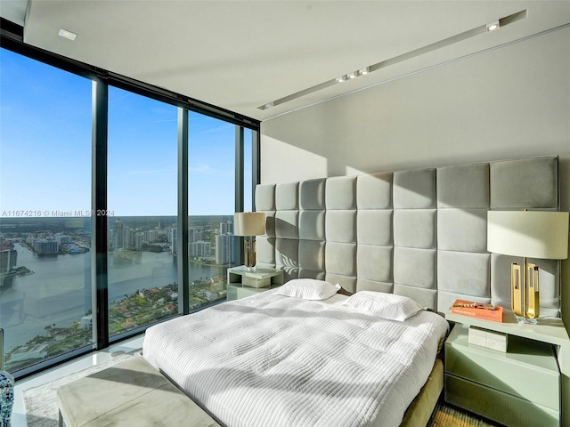 bedroom featuring expansive windows and a water view