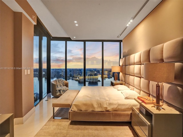 bedroom with a wall of windows and a water view