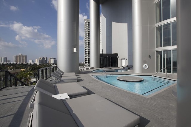 view of pool featuring a jacuzzi and a patio area