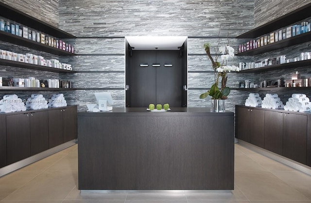 bar featuring dark brown cabinetry and light tile patterned floors