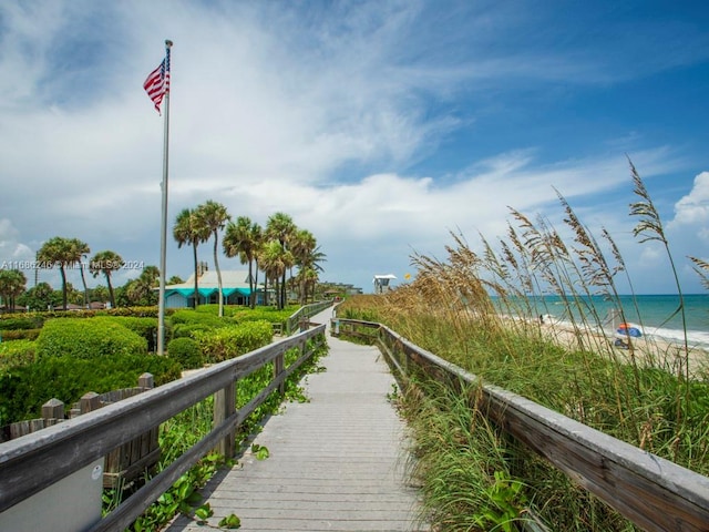 view of community featuring a water view and a beach view