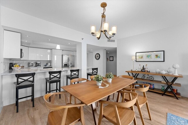 dining area featuring a notable chandelier and light hardwood / wood-style flooring