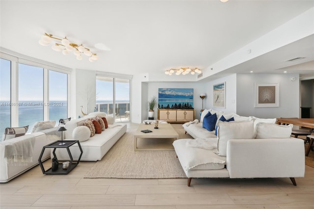 living room with light hardwood / wood-style floors and a water view