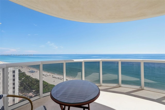 balcony featuring a beach view and a water view