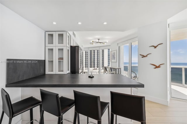 kitchen with white cabinetry, kitchen peninsula, plenty of natural light, and a water view