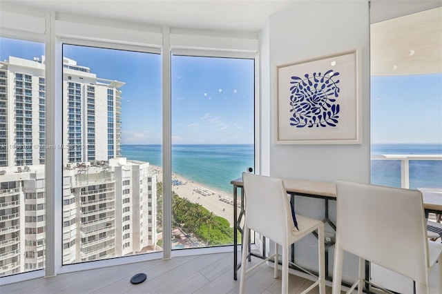 sunroom featuring a view of the beach and a water view