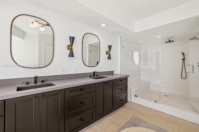 bathroom featuring walk in shower, vanity, and hardwood / wood-style flooring