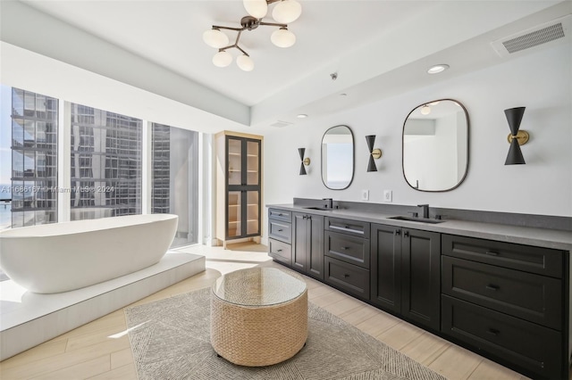 bathroom with vanity, a washtub, and hardwood / wood-style floors