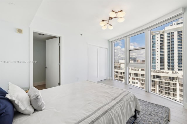 bedroom with floor to ceiling windows and hardwood / wood-style floors