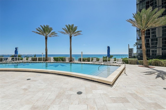 view of pool featuring a patio area and a water view