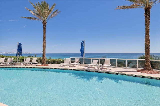 view of pool with a patio area and a water view