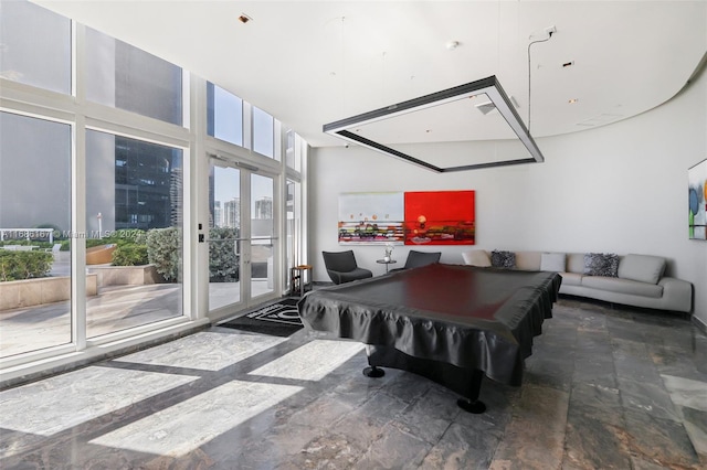 game room featuring billiards, a wall of windows, and a high ceiling