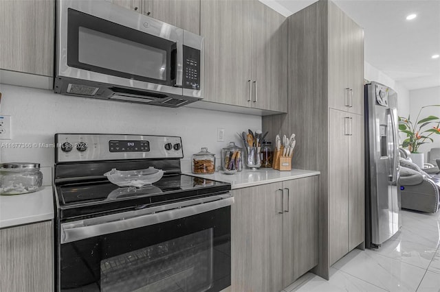 kitchen featuring light brown cabinetry and appliances with stainless steel finishes