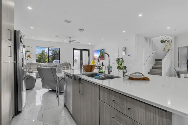 kitchen with appliances with stainless steel finishes, sink, gray cabinets, and ceiling fan