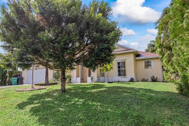 view of front of home with a front yard and a garage