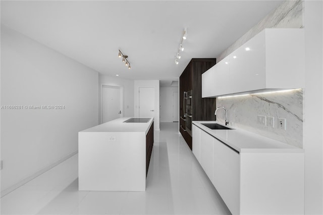 kitchen featuring white cabinets, a kitchen island, stainless steel oven, and sink