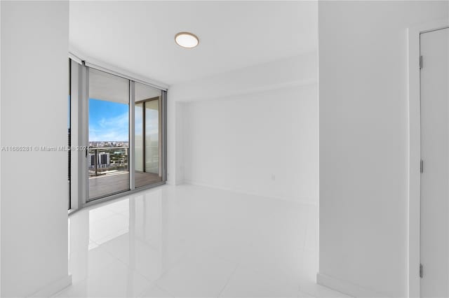 empty room featuring floor to ceiling windows and light tile patterned flooring