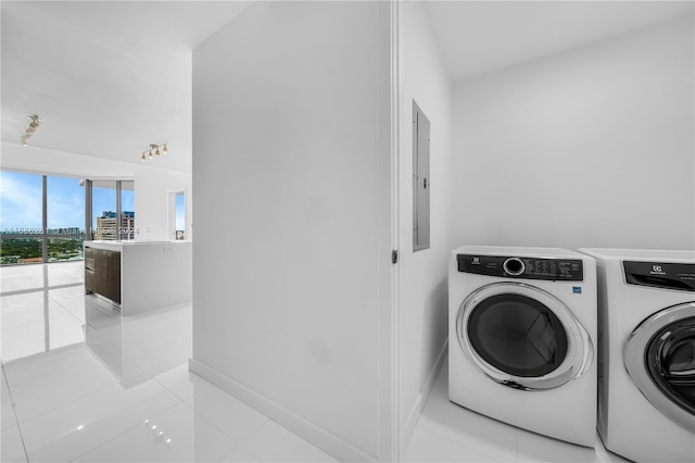 laundry area featuring electric panel, light tile patterned flooring, and washer and dryer