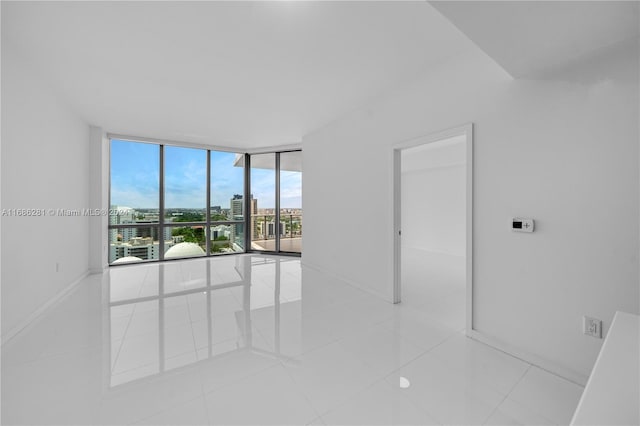 tiled spare room featuring expansive windows