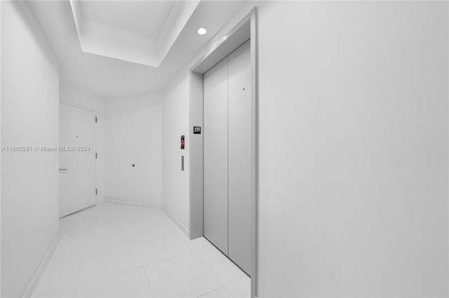 hall with light tile patterned floors and elevator