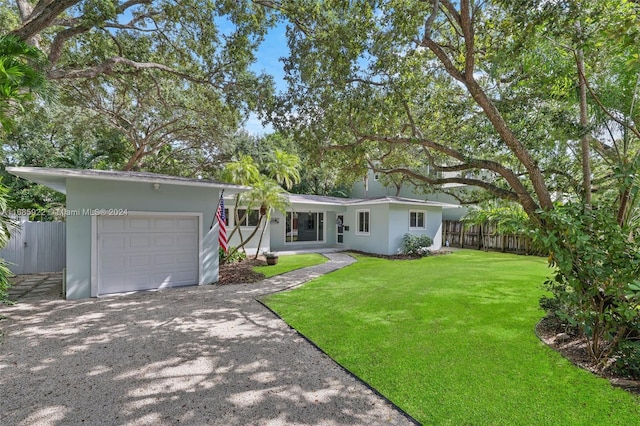 single story home featuring a garage and a front yard