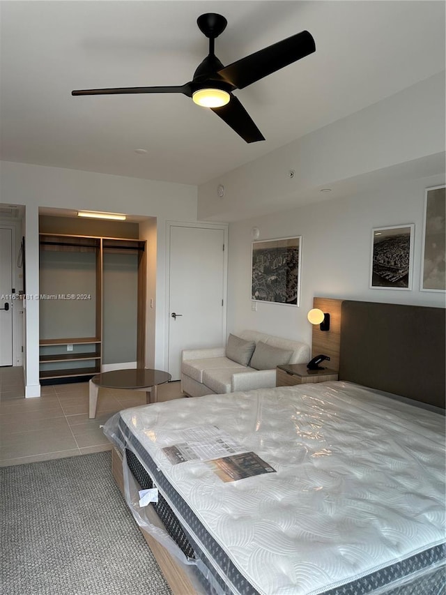 bedroom featuring light tile patterned flooring, ceiling fan, and a closet