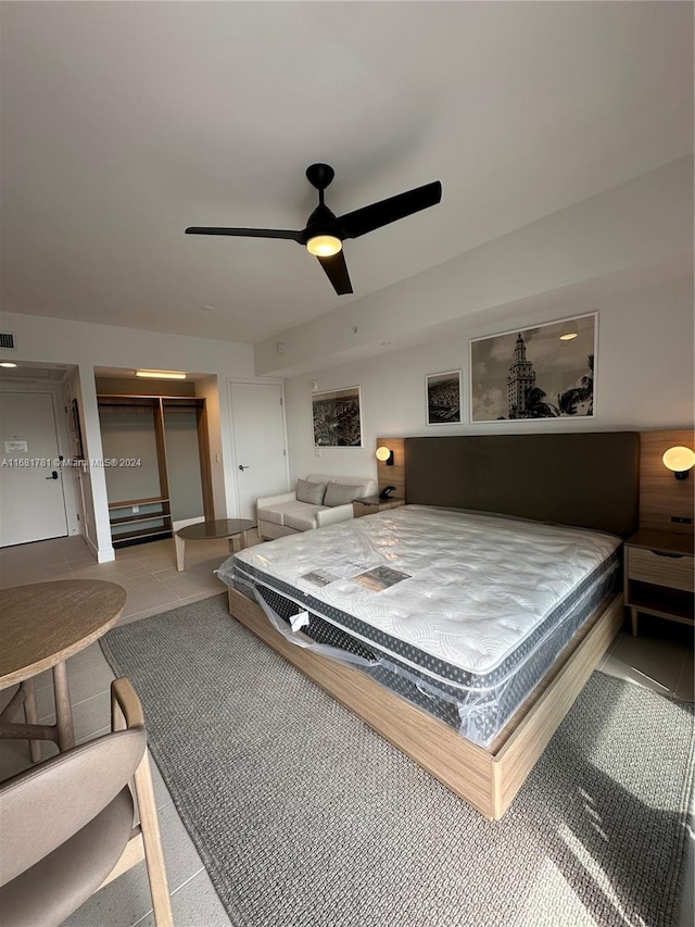 bedroom featuring light tile patterned floors, ceiling fan, a closet, and a spacious closet