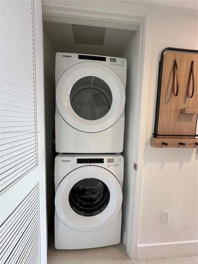 washroom featuring light tile patterned flooring and stacked washer / dryer