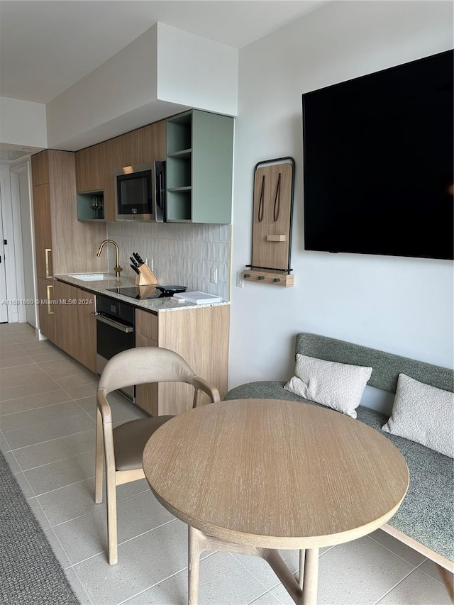 kitchen featuring backsplash, appliances with stainless steel finishes, sink, and light tile patterned flooring