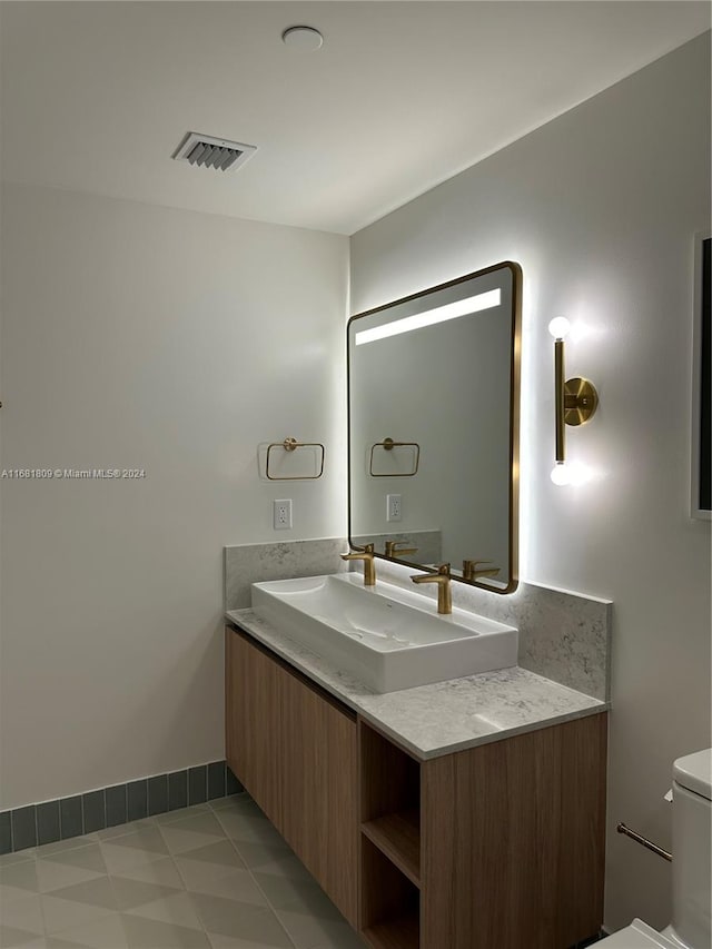 bathroom featuring vanity, tile patterned floors, and toilet