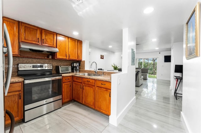 2650 NW 28th St Unit 908-9, Miami, FL 33142 - kitchen with a sink, brown cabinetry, under cabinet range hood, and stainless steel appliances