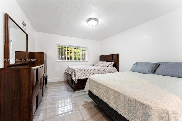 2650 NW 28th St Unit 908-9, Miami, FL 33142 - bedroom featuring baseboards and a textured ceiling