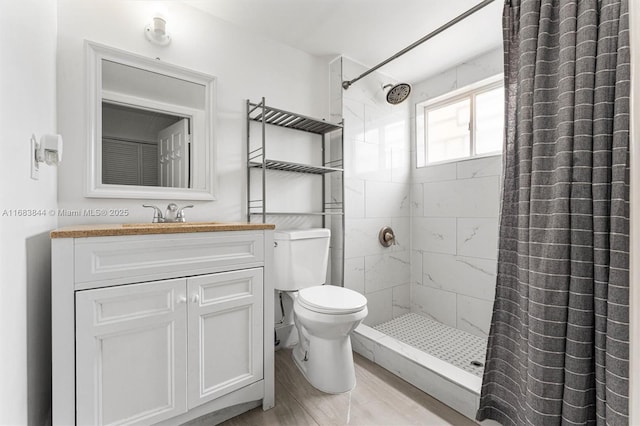 2650 NW 28th St Unit 908-9, Miami, FL 33142 - full bathroom with vanity, toilet, wood finished floors, and a stall shower