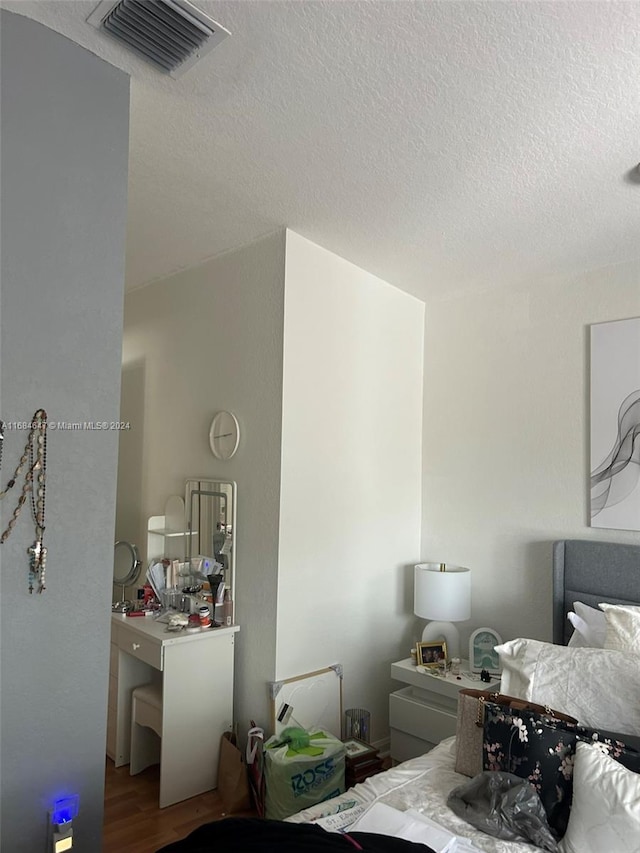 bedroom featuring a textured ceiling and hardwood / wood-style floors