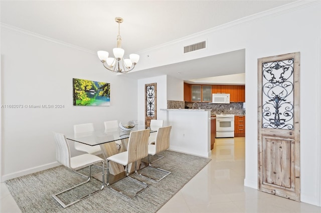 16699 Collins Ave Unit 2202, Sunny Isles Beach, FL 33160 - dining room with crown molding, a chandelier, light tile patterned floors, and baseboards