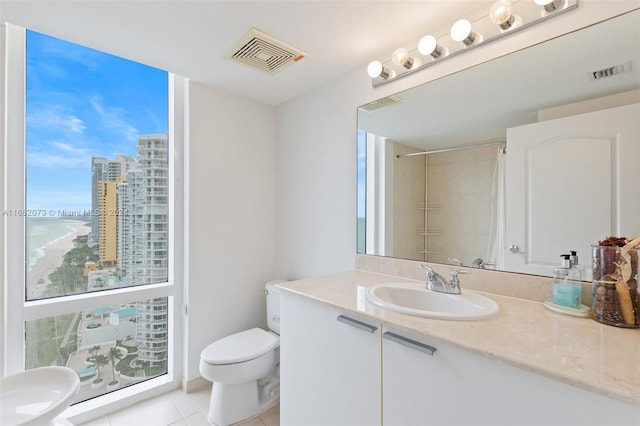 bathroom featuring toilet, curtained shower, a healthy amount of sunlight, and vanity