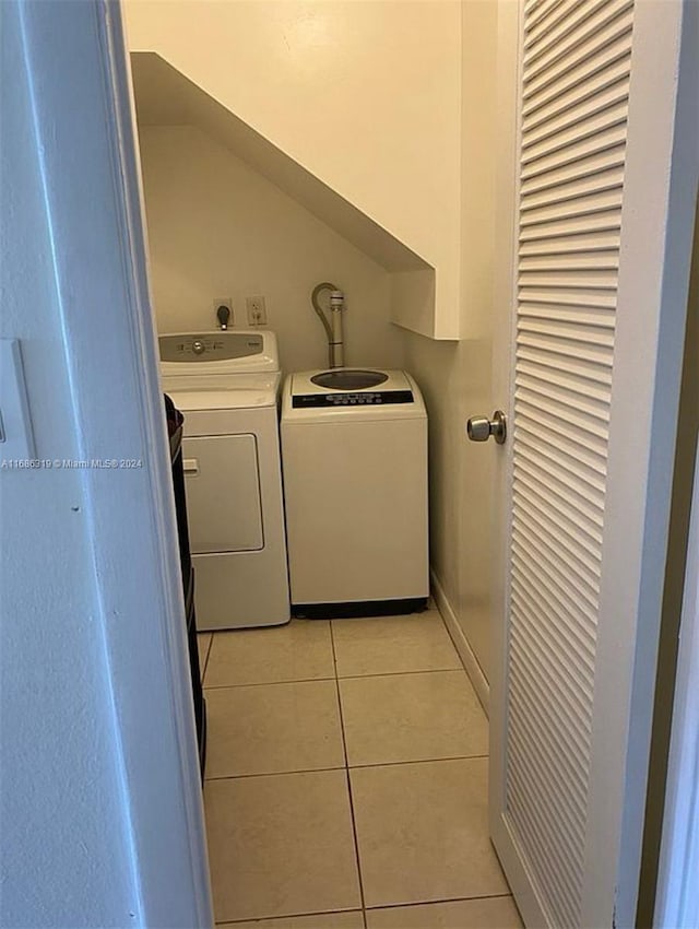 washroom with washer and dryer and light tile patterned floors