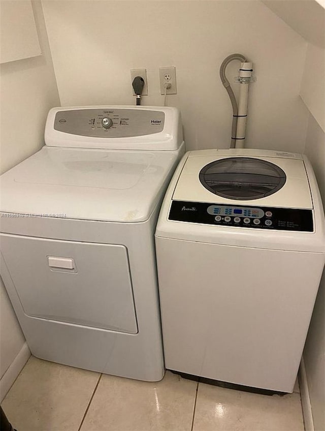 laundry room with washing machine and clothes dryer and light tile patterned floors