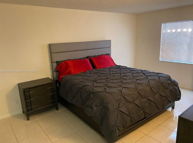 bedroom with a textured ceiling and light tile patterned floors