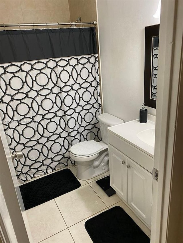 bathroom with vanity, a shower with curtain, toilet, and tile patterned floors