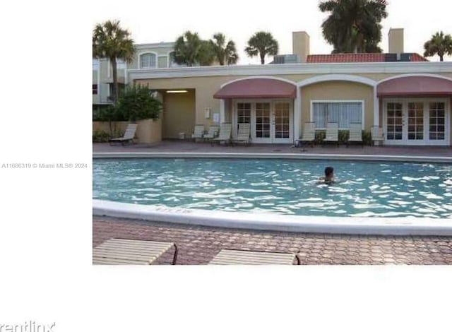 view of pool with french doors and a patio area