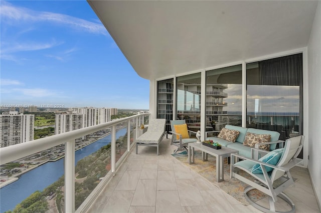 balcony featuring outdoor lounge area and a water view