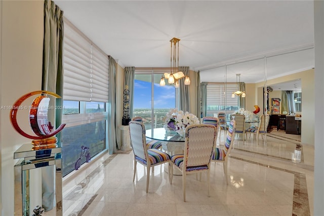 dining room featuring a notable chandelier, ornamental molding, and a wealth of natural light