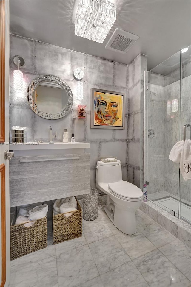 bathroom with vanity, toilet, a shower with shower door, and an inviting chandelier