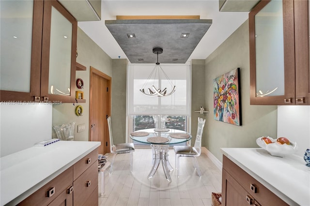 dining area with light wood-type flooring and a chandelier